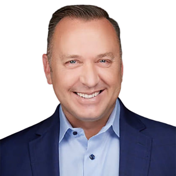 A smiling man with short, light brown hair wearing a blue blazer over a light blue shirt, against a white background.